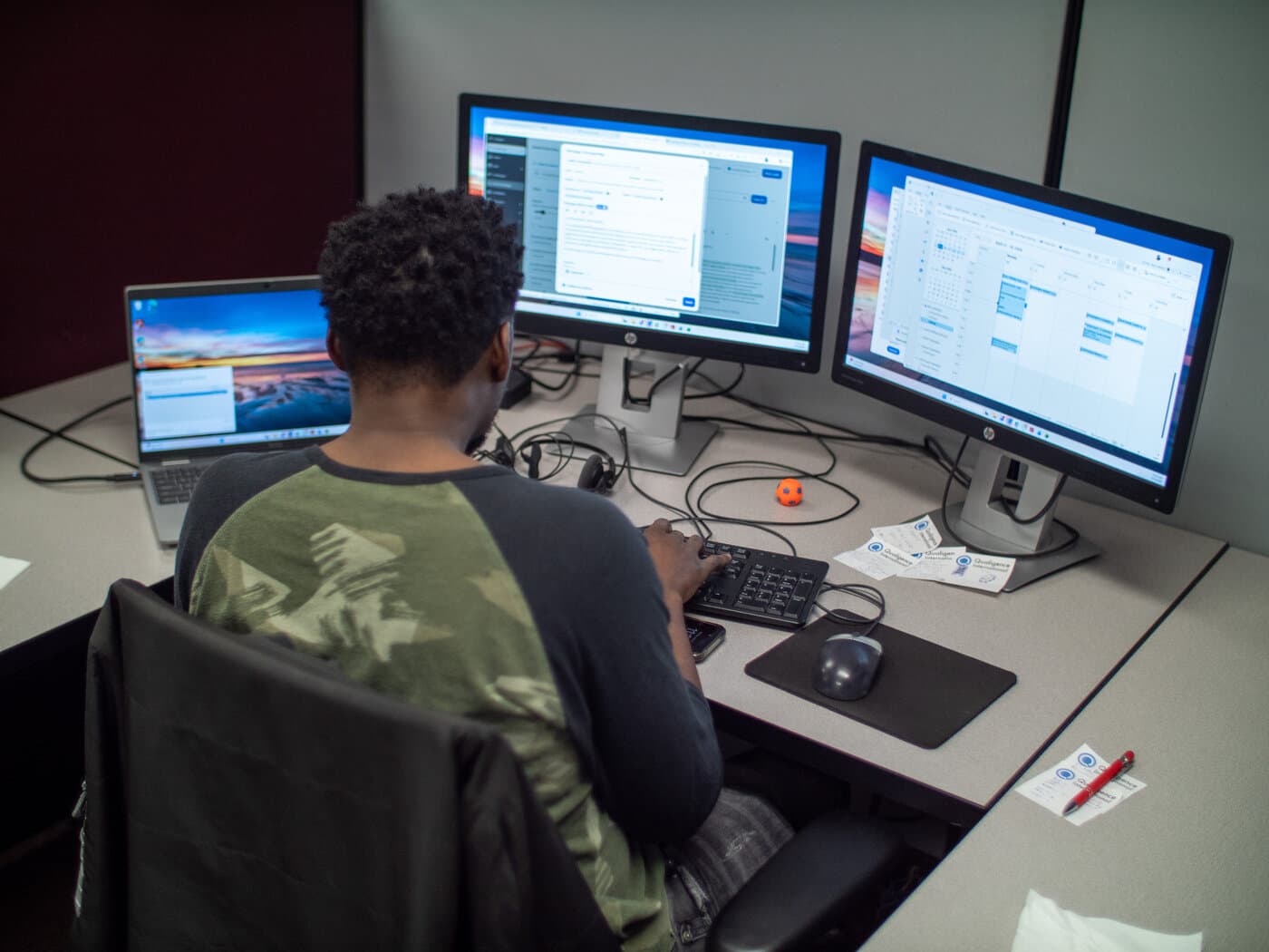 Qualigence team members working together at desks inside the Livonia, Michigan office